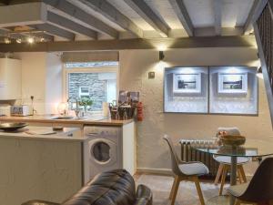 a kitchen with a washing machine and a table with chairs at Stables Grasmere in Grasmere
