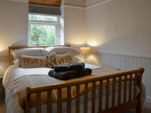 a bed with a dog sitting on top of it at Stables Grasmere in Grasmere