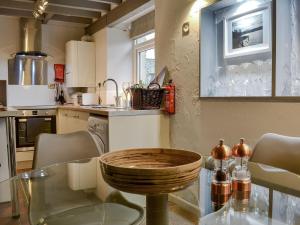a kitchen with a glass table with chairs and a counter at Stables Grasmere in Grasmere