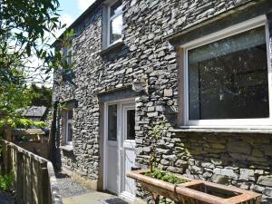 a stone house with a white door and a window at Stables Grasmere in Grasmere
