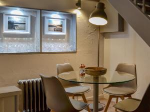 a dining room with a glass table and chairs at Stables Grasmere in Grasmere +6 photos