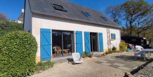 a house with blue doors and a table and chairs at Ch'ti Tichenn GR34 in Saint-Michel-en-Grève