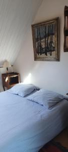 a bedroom with a bed with a picture on the wall at Ch'ti Tichenn GR34 in Saint-Michel-en-Grève