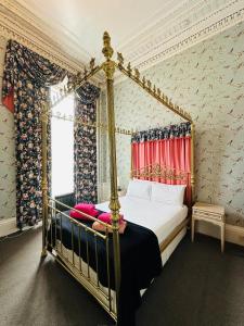ein Schlafzimmer mit Himmelbett und Fenster in der Unterkunft Eliza House in Edinburgh