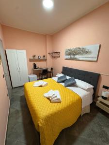 a bedroom with a yellow bed with towels on it at B&B Da Simone in Battipaglia