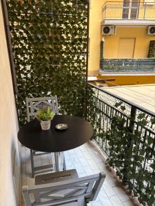 a table and chairs on a balcony with a green wall at B&B Da Simone in Battipaglia