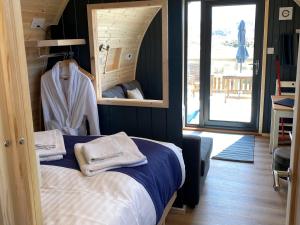 a bedroom with a bed and a mirror with towels at Maggie's Cabin in Oban