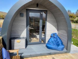 a circular house with a blue bag on the porch at Maggie's Cabin in Oban