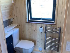 a small bathroom with a toilet and a window at Maggie's Cabin in Oban