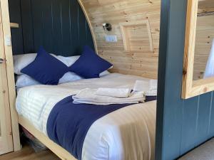 a bed with blue pillows and towels on it at Maggie's Cabin in Oban +26 photos