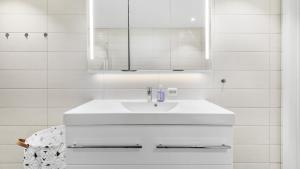 a white bathroom with a sink and a mirror at Kvitefjell 35 in Loen +17 photos
