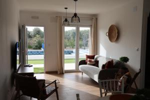 a living room with a couch and a sliding glass door at Olivale Villas in Campo Maior