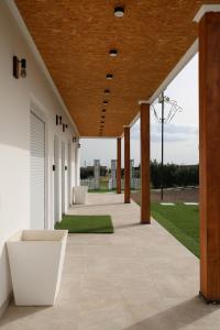 an outdoor patio with wooden ceilings and green grass at Olivale Villas in Campo Maior