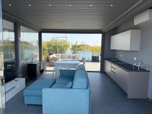 a living room with a blue couch and a table at Elegance Suite Apartments - Siroli Collection in Cervia