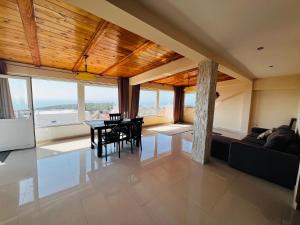 a living room with a table and chairs and windows at Bird House in Krimovice