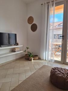 a living room with a flat screen tv and a sliding glass door at T2 Apart - Beach View - Santa Maria Center in Santa Maria