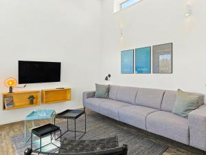 a living room with a couch and a flat screen tv at Holiday Home Haus Schmidt - 305 by Interhome in Lembruch