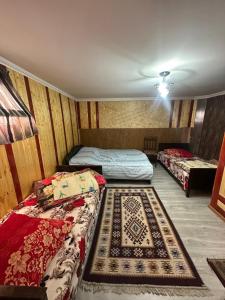 a room with three beds and a rug at Guest House Iura in Sighnaghi +31 photos