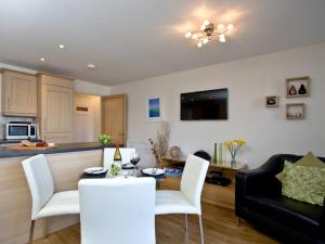 a kitchen and living room with a table and chairs at 1 Harbour View in Newquay