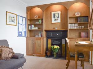 a living room with a fireplace and book shelves at Castle Peroch-Uk5698 in Logierait