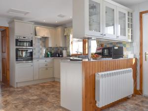 a kitchen with white cabinets and a refrigerator at Castle Peroch-Uk5698 in Logierait +8 photos
