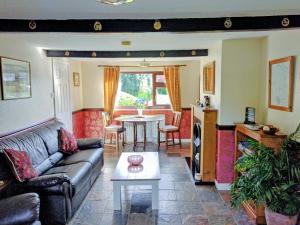 a living room with a couch and a table at White Cottage in Hemingby