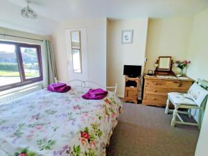 a bedroom with a bed and a dresser and a window at White Cottage in Hemingby