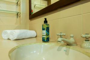 a bottle of soap sitting on a bathroom sink at Estalagem Entardecer da Serra in Monte Verde +80 photos