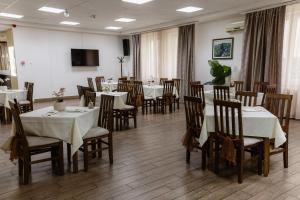 a dining room with tables and chairs and a tv at Hotel N in Belgrade