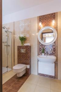 a bathroom with a sink toilet and a mirror at Leszczynowy Dworek in Gdańsk