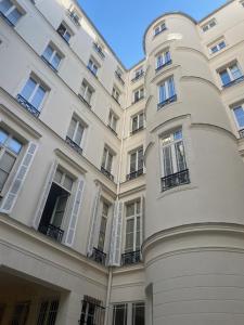 a large white building with windows on the side at 1er Etage Opéra in Paris