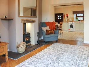 a living room with a chair and a fireplace at Beudy Newydd - Uk50959 in Llanllechid