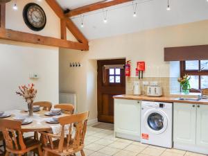 a kitchen and dining room with a table and a dishwasher at Beudy Newydd - Uk50959 in Llanllechid +9 photos