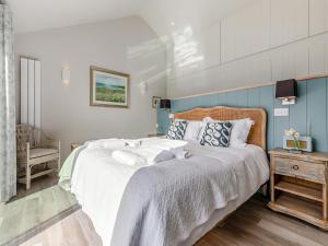 a bedroom with a large bed with white sheets at Long Commons in Saint Mawes