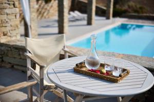 a table with a tray of fruit and a glass vase at Villa Litharia, enchanting location and view in Ioulis
