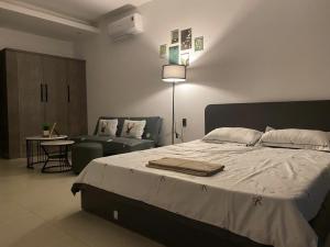 a bedroom with a large bed and a couch at SOHA House in Rạch Giá +9 photos