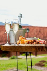 two glasses of white wine and food on a table at Estalagem Entardecer da Serra in Monte Verde