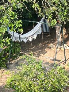 a hammock in the middle of a garden at Lugar das Andorinhas in Olhos de Água