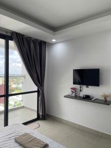 a bedroom with a flat screen tv on the wall at SOHA House in Rạch Giá