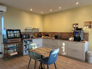 a kitchen with a table and chairs and a counter at Les Bains Boyardville - Hôtel et Restaurant in Boyard-Ville +128 photos