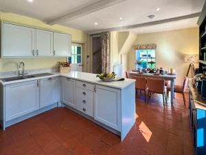 a kitchen with white cabinets and a dining room at Falconer's Lodge in Didlington