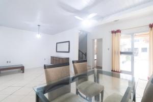 a dining room with a glass table and chairs at Guest House Central in Florianópolis