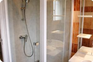a shower with a glass door next to a sink at Gîte Le Verdon in Quinson +23 photos