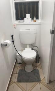 a bathroom with a toilet with a window and a rug at The Valley View Guest House in Melbourne +13 photos