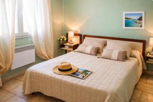 a bedroom with a bed with a hat on it at Gîte Le Verdon in Quinson