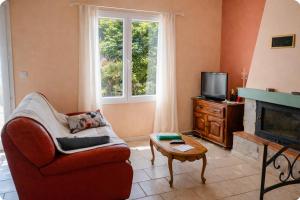 a living room with a couch and a television at Gîte Le Verdon in Quinson