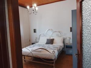 a bedroom with a white bed and a chandelier at B&B Casa Orchidea in Baragazza