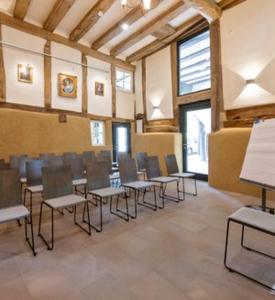 a classroom with chairs and tables in a room at Gut Junkernhof in Calden