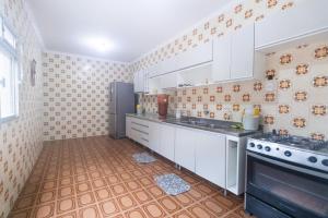 a large kitchen with white cabinets and a stove at Guest House Central in Florianópolis