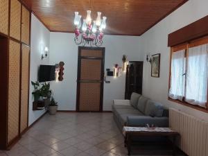 a living room with a couch and a chandelier at B&B Casa Orchidea in Baragazza